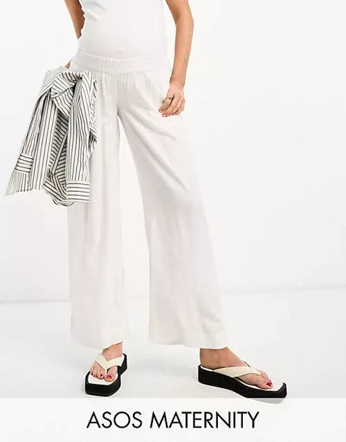 Mujer con pantalón de lino blanco premamá