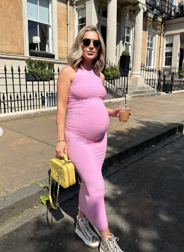 Ella ravenscroft posing with pink maternity bodycon dress