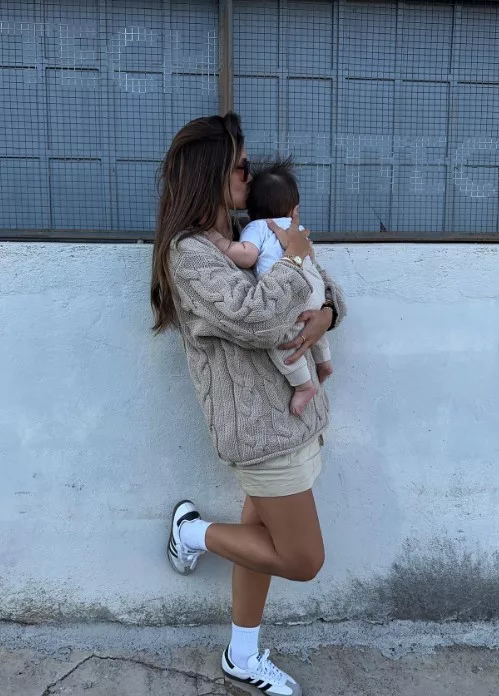 Pregnant woman wearing adidas samba shoes while holding newborn instagram