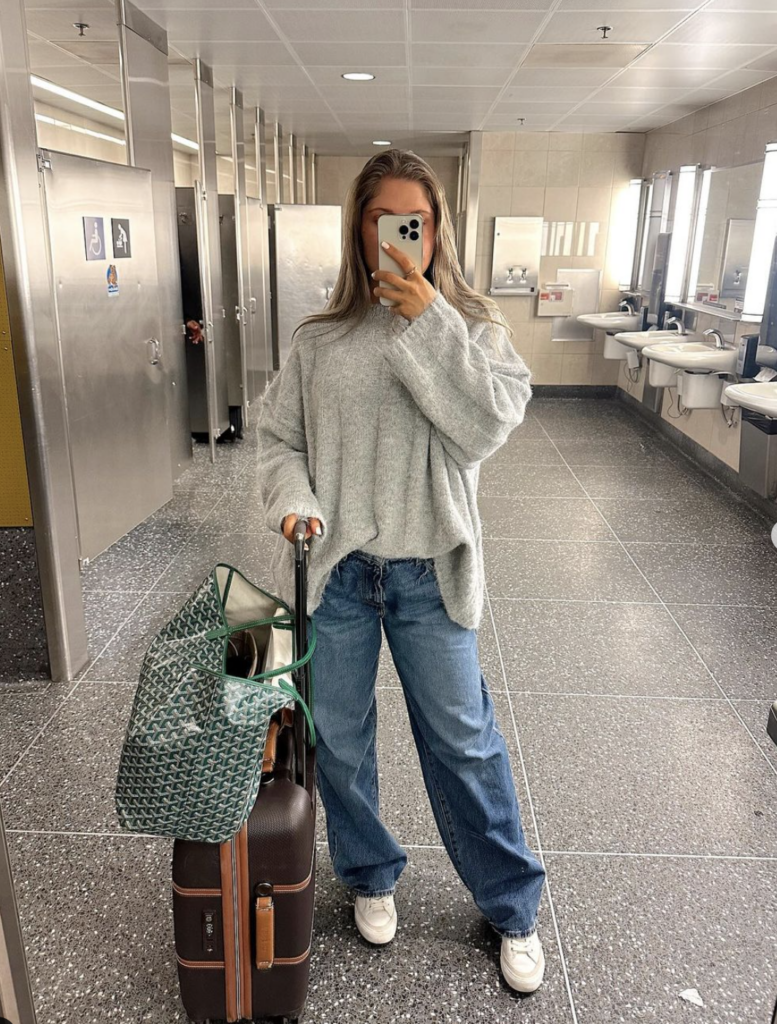 Woman in baggy jeans and oversized jumper with white sneakers